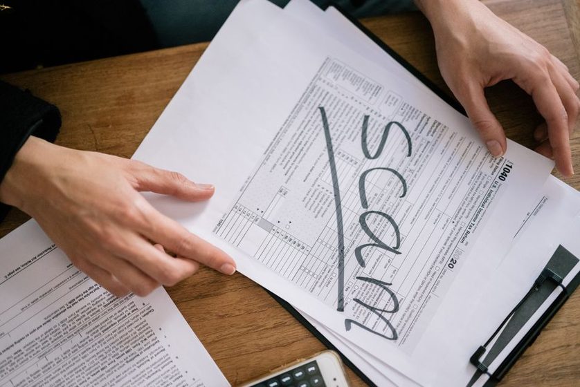 Duas pessoas conferem um formulário de declaração de imposto de renda sobre a mesa.